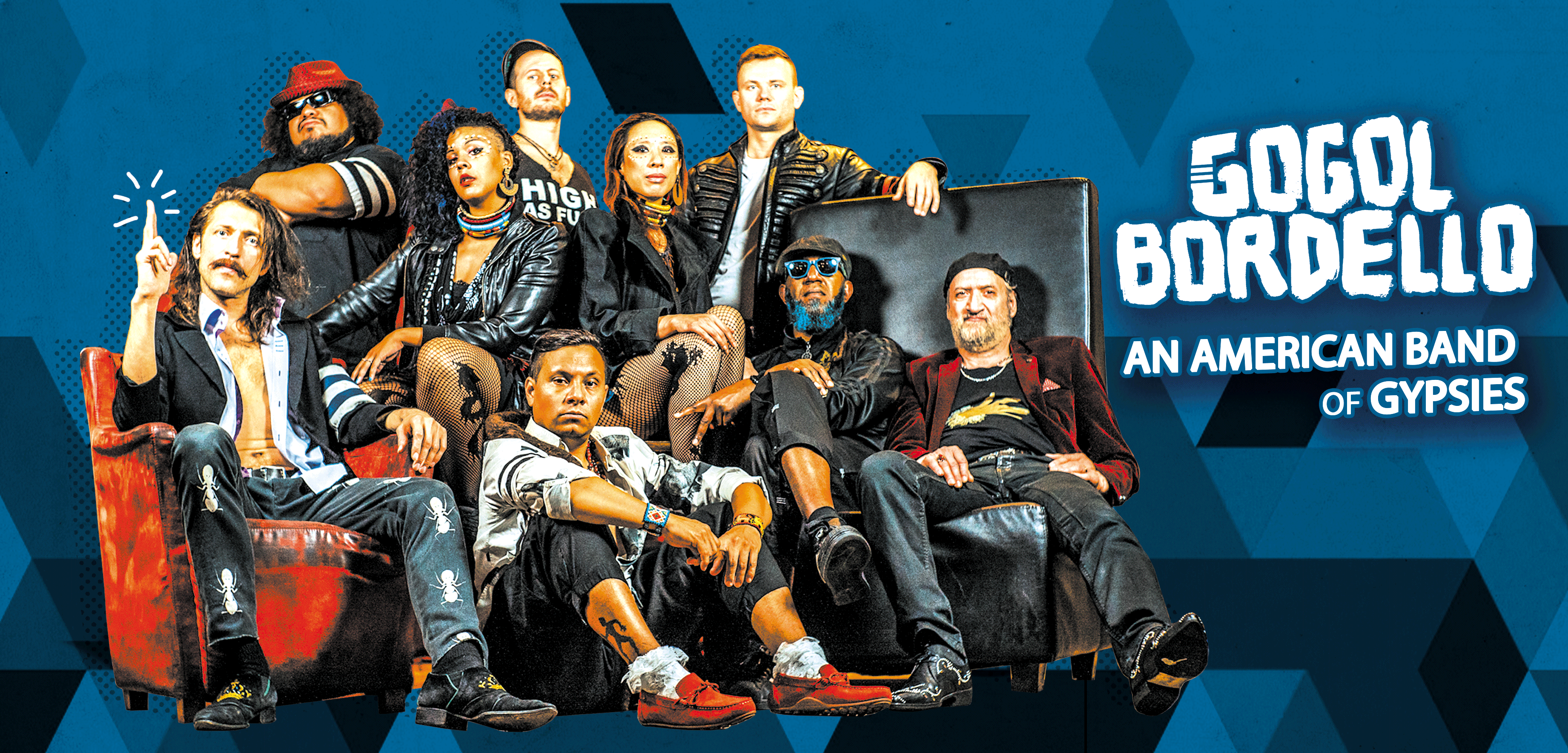 Gogol Bordello members pose on leather couches against a blue geometric backdrop, some in jackets and sunglasses.
