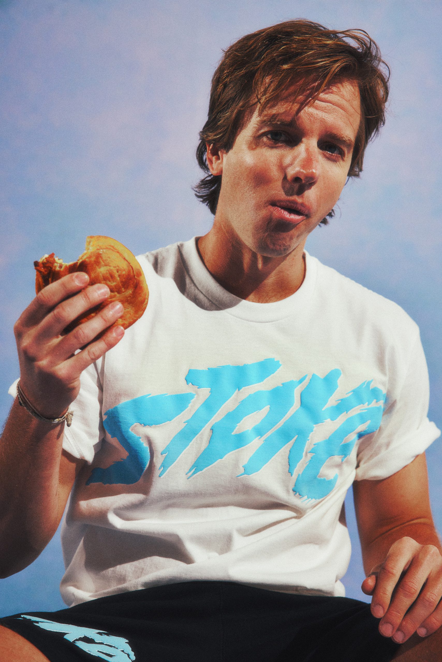 Chad Kroeger eating a burger wearing a Stoka t-shirt