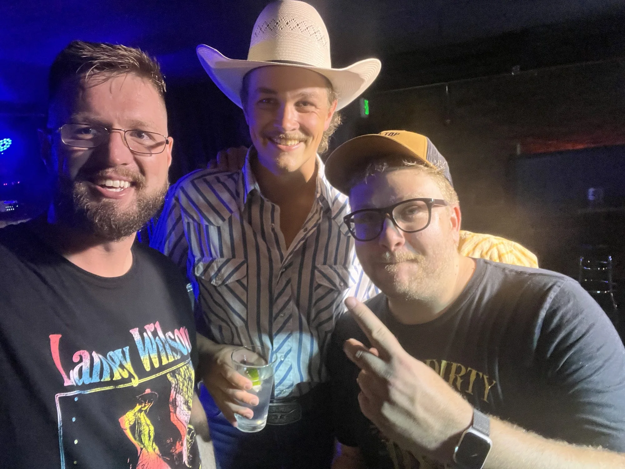 Zach Top in a white cowboy hat between BandWagon promoters Ely Corliss and Ham Byrd after his show.