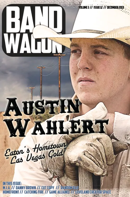 Young man in a cream cowboy hat and worn gloves holds a wooden post beside a dirt road and utility poles.