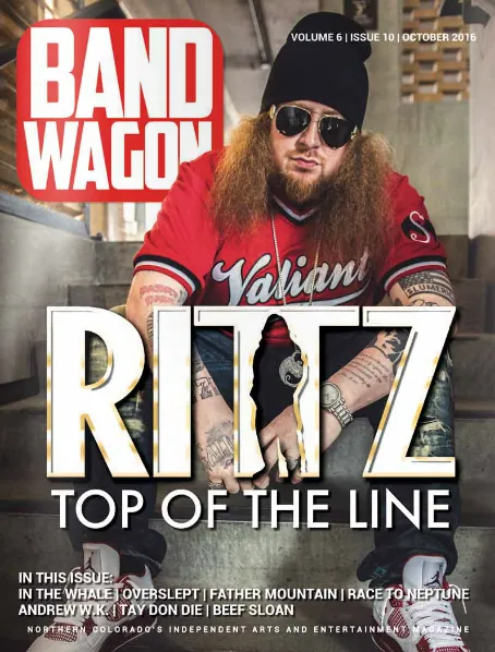 Rittz poses on concrete steps in a black beanie, sunglasses, and red Valiant jersey, tattooed arms visible.