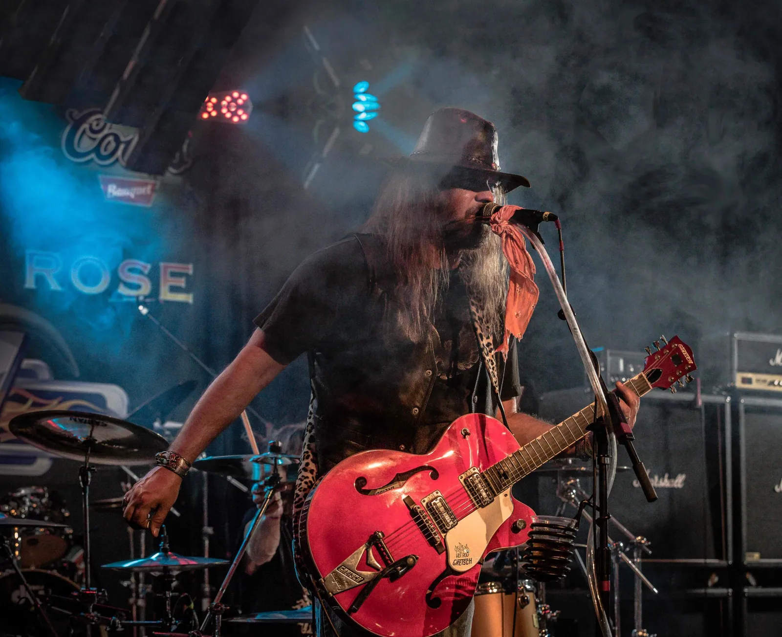 Michael Morrow & The Culprits on stage: bearded singer in a hat plays a red guitar in smoke and blue light.