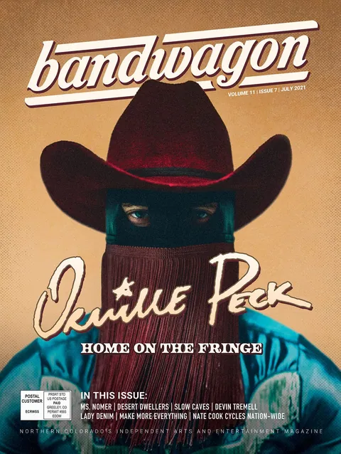 Orville Peck cover portrait: a masked figure in a red cowboy hat and maroon fringe veil, wearing a teal jacket.