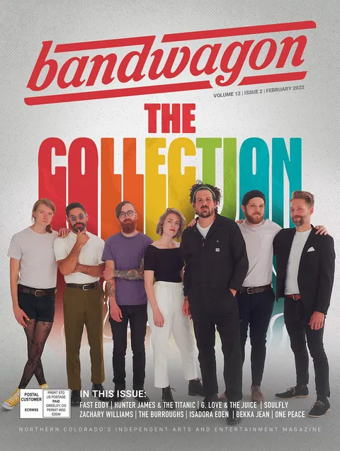 Six people stand in a row in front of a rainbow-colored "The Collection" backdrop on a magazine cover.