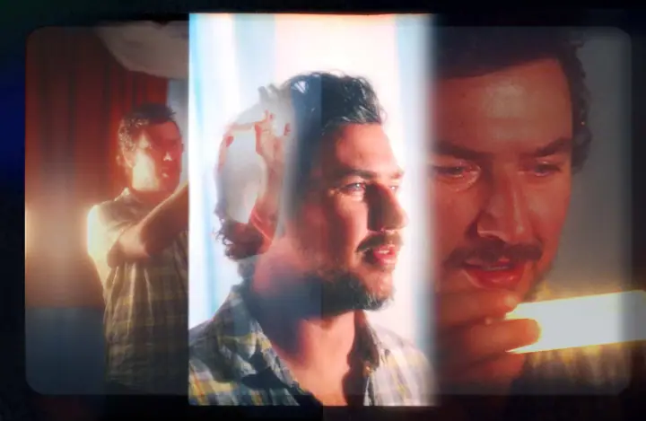 Layered triple-exposure portrait of a bearded man in a plaid shirt, lit warmly beside a sheer curtain.