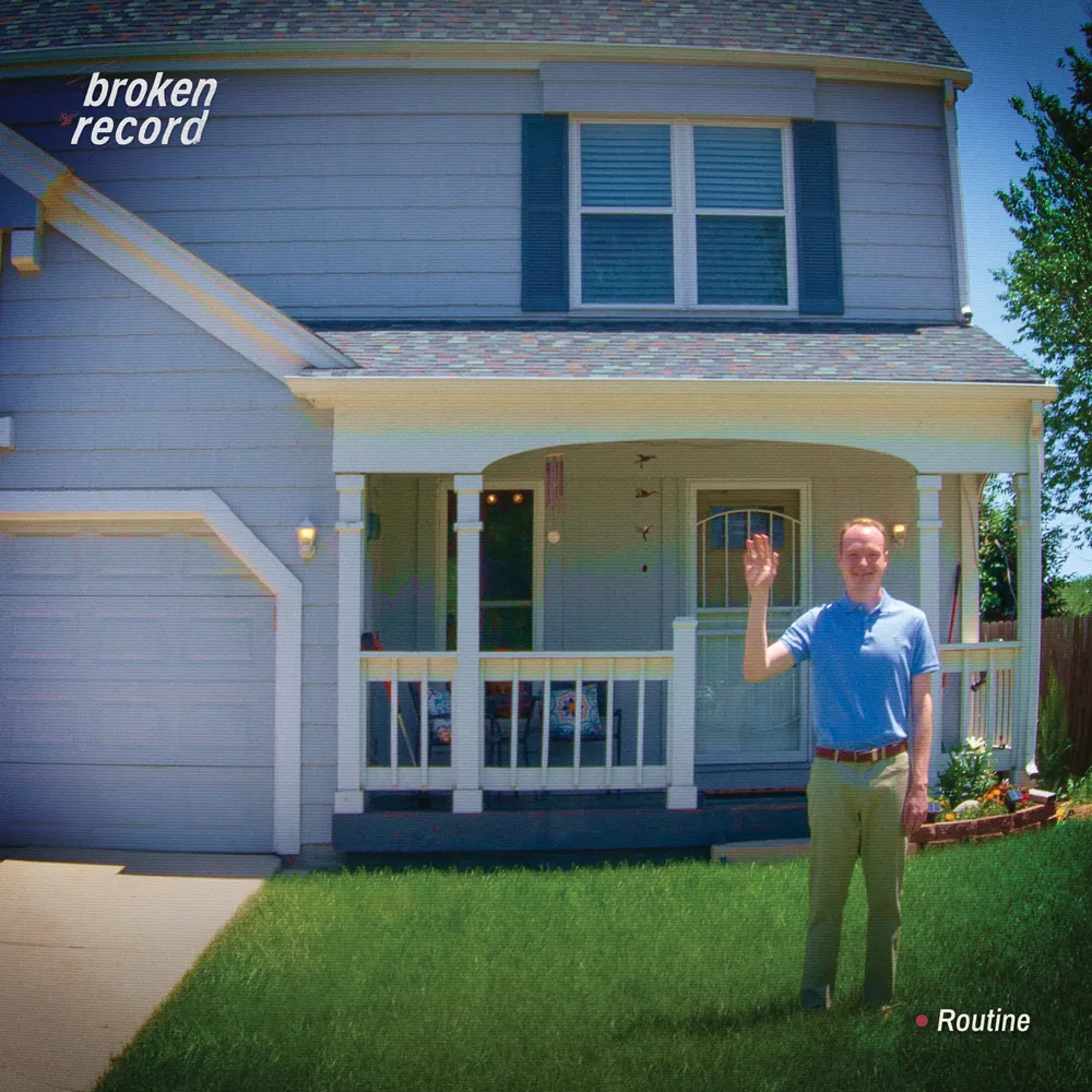 Album cover showing a smiling man in a blue polo waving on a lawn in front of a two-story suburban house with a porch.